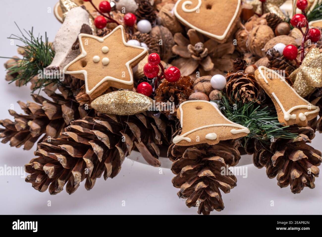 Adornos navideños con conos de pino, nueces y galletas de Navidad hechas a mano Foto de stock