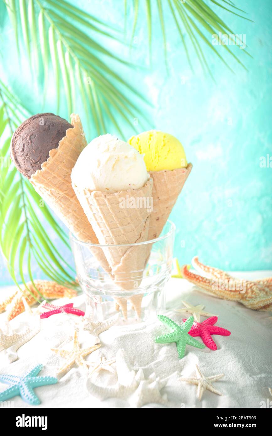 Verano tropical mar vacaciones concepto. Tres helado waffle conos con  diferentes sabores de helado, en la arena con conchas y estrellas de mar, l  Fotografía de stock - Alamy