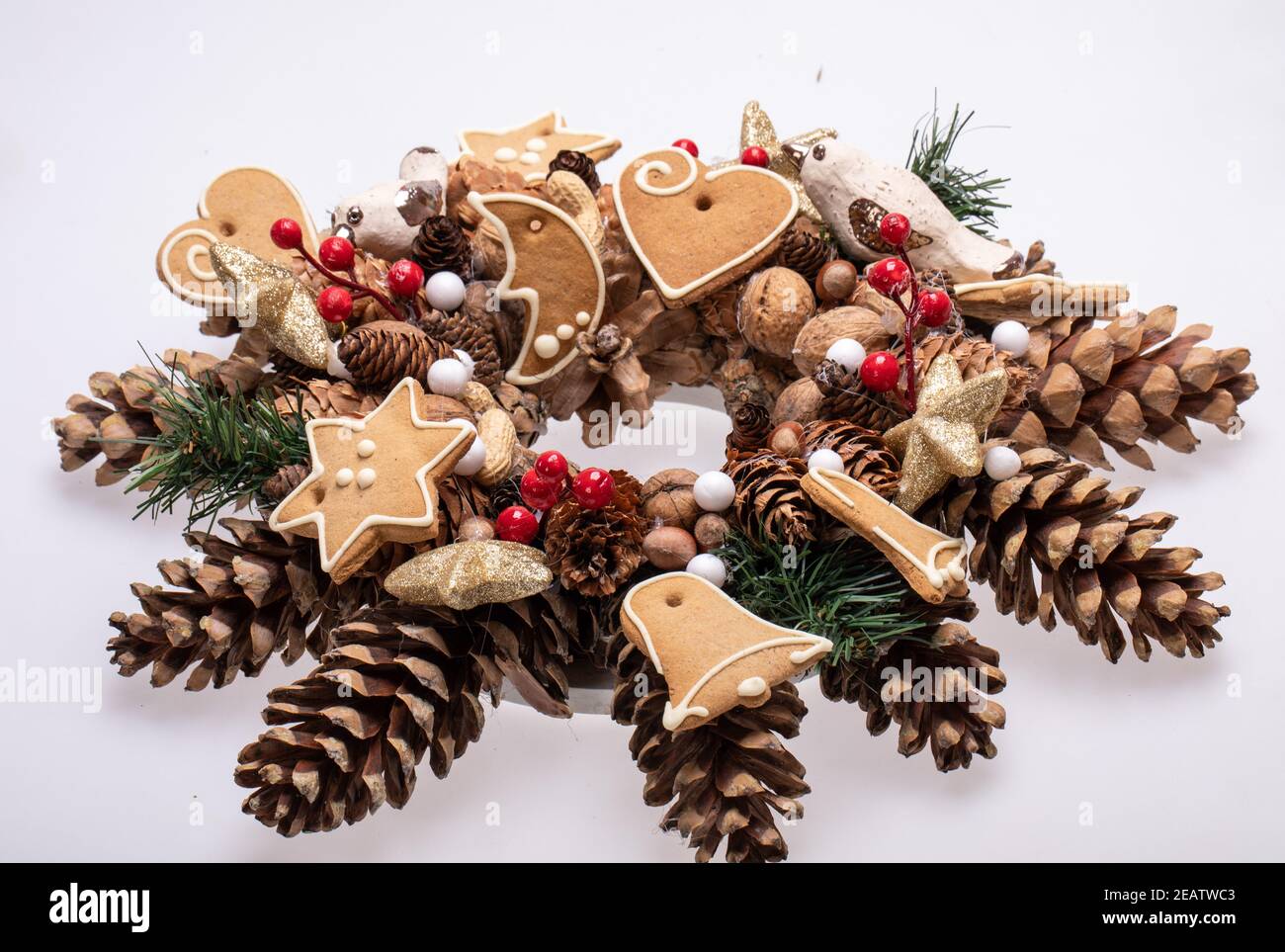 Adornos navideños con conos de pino, nueces y galletas de Navidad hechas a mano Foto de stock