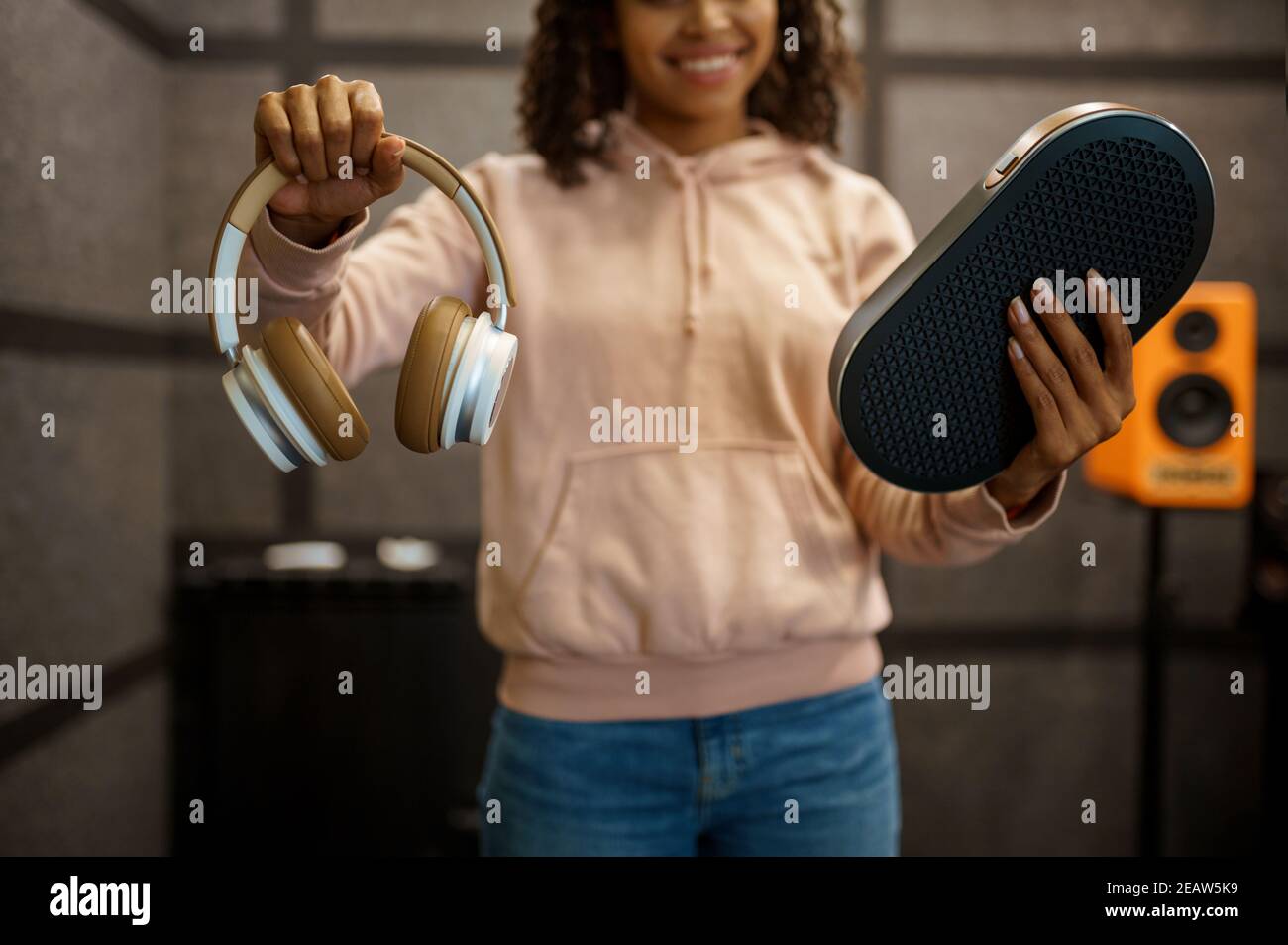 Mujer mostrando auriculares en la tienda del sistema de altavoces Foto de stock