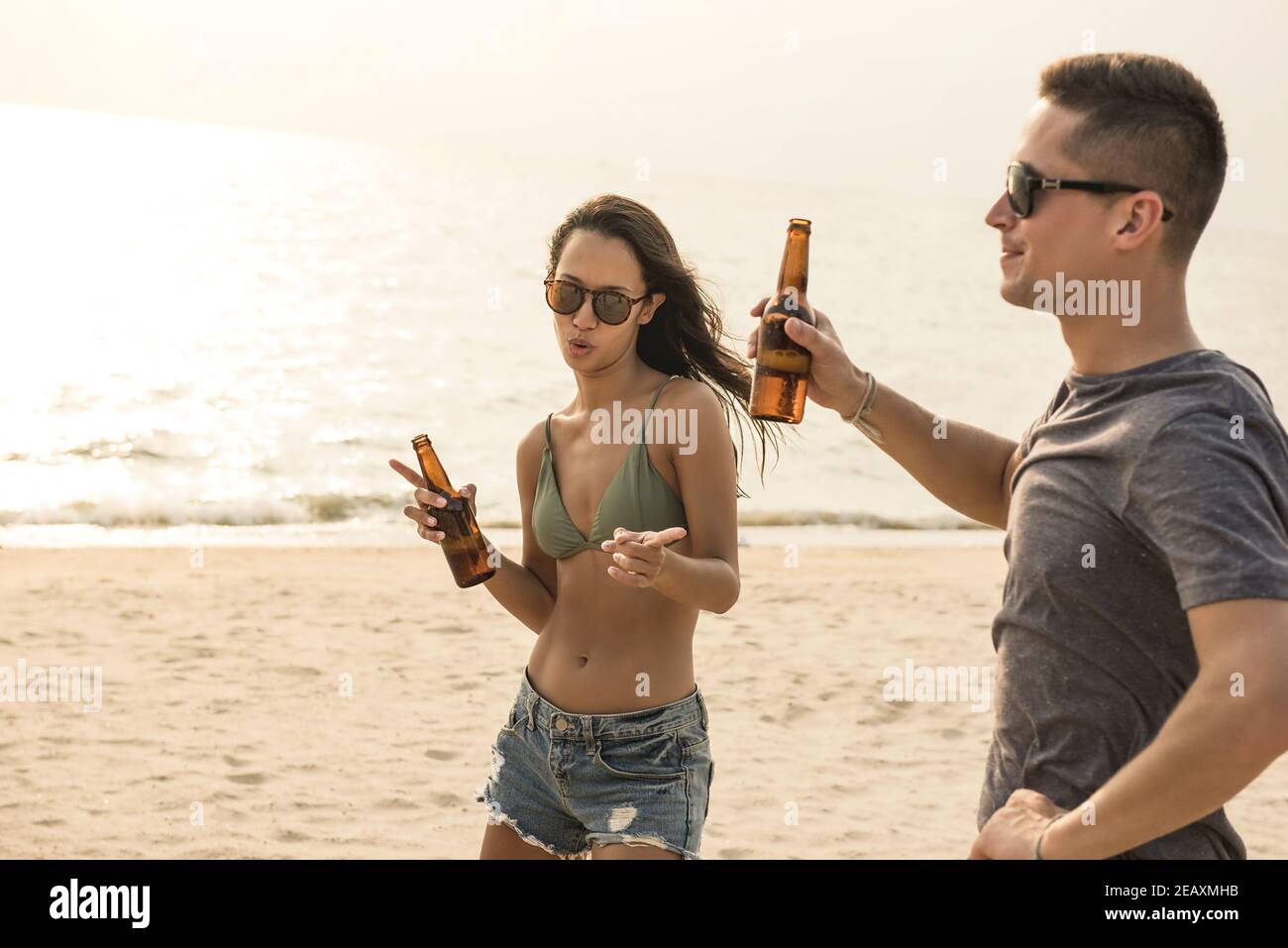 Grupo de amigos con fiesta bailando y bebiendo cerveza la playa en verano Foto de stock