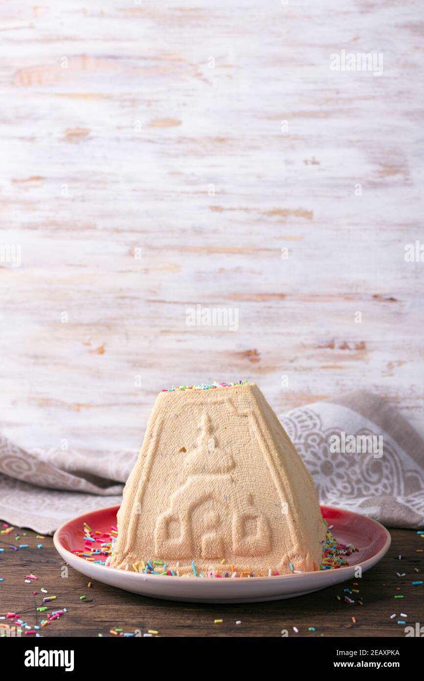 Tradicional postre de queso de Pascua ruso, Paskha Ortodoxo, con leche  condensada hervida y frutos secos rociados con azúcar en una mesa de madera  Fotografía de stock - Alamy