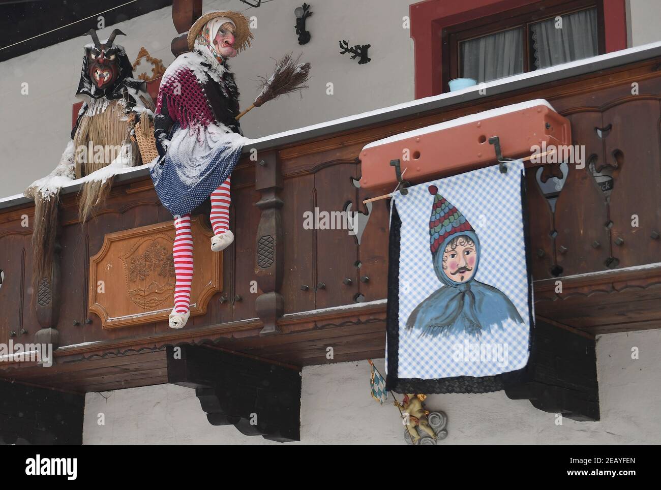 Farchant, Alemania. 11 de febrero de 2021. Las figuras tradicionales del  carnaval, que suelen ser usadas por los lugareños en el tradicional  Maschkera-Gehen, están decoradas en un balcón. Este año, brujas, gnomos,