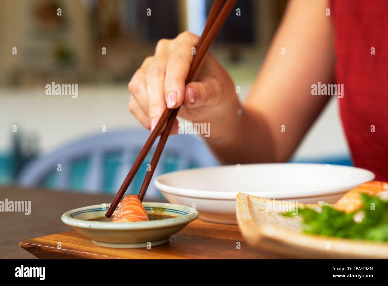 Sashimi de salmón con salsa de soja fue recogido con palillos Foto de stock