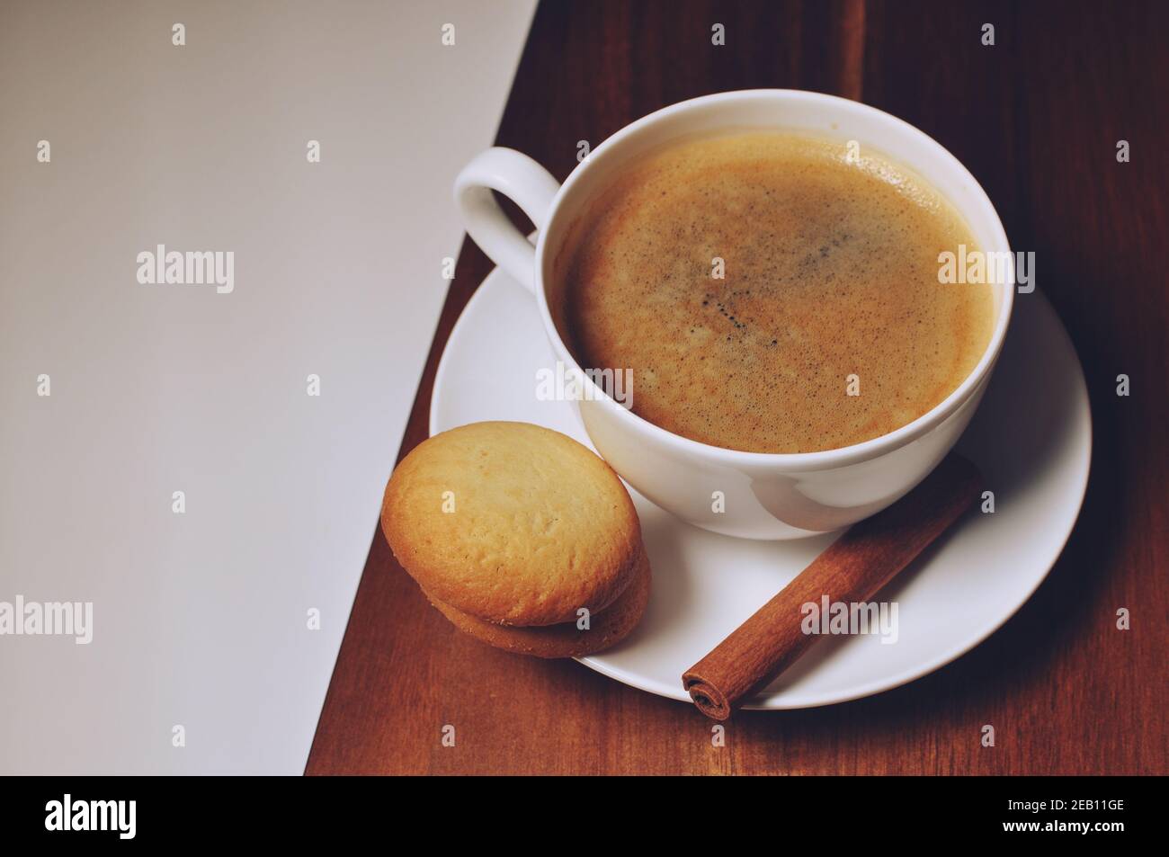 Taza de café caliente con canela y galletas decoracion sobre fondo de mesa marrón de madera. Tabla superior, copiar texto Foto de stock