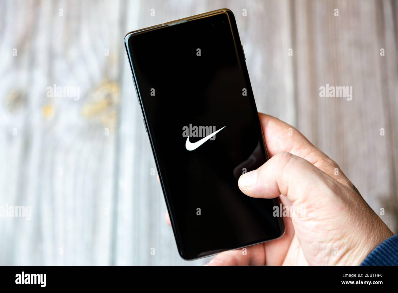 Un teléfono móvil o celular que está en manos de un Mano con la aplicación  Nike abierta en la pantalla Fotografía de stock - Alamy