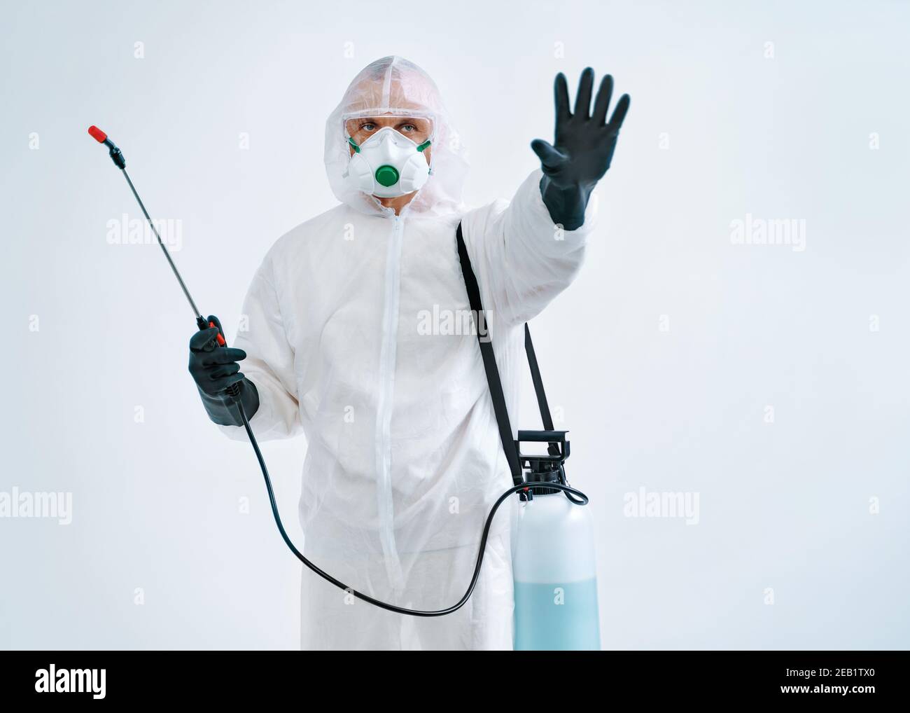 Trabajador desinfectante en traje protector mostrando el gesto de parada, para controlar un brote de virus Foto de stock