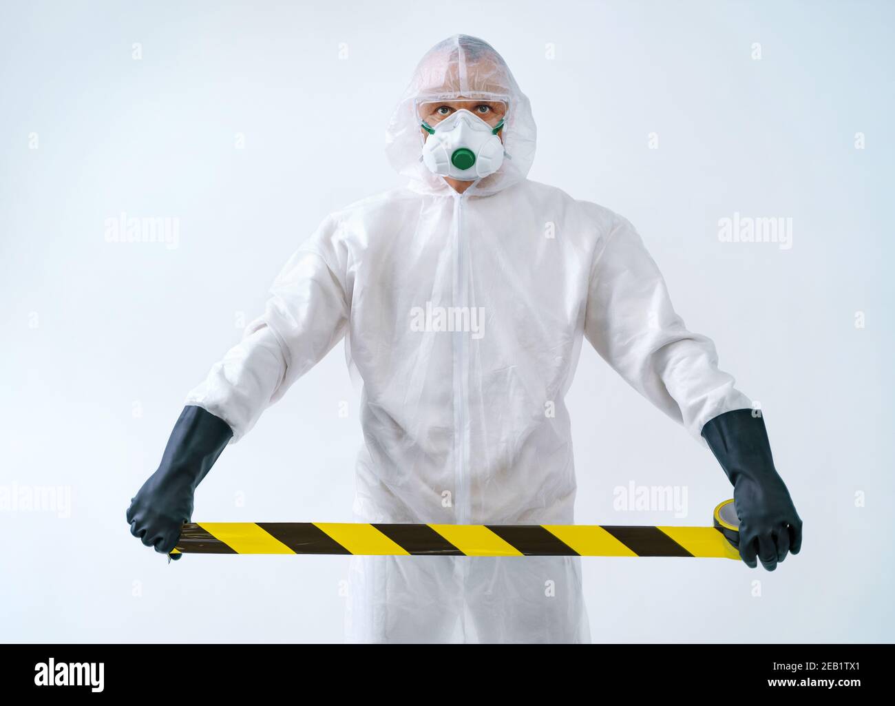 Trabajador de salud acordonando fuera de la zona con cinta de barrera durante un brote de virus Foto de stock