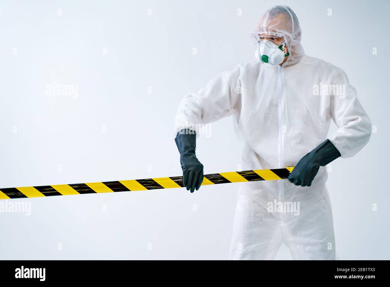Trabajador de salud acordonando fuera de la zona con cinta de barrera durante un brote de virus Foto de stock