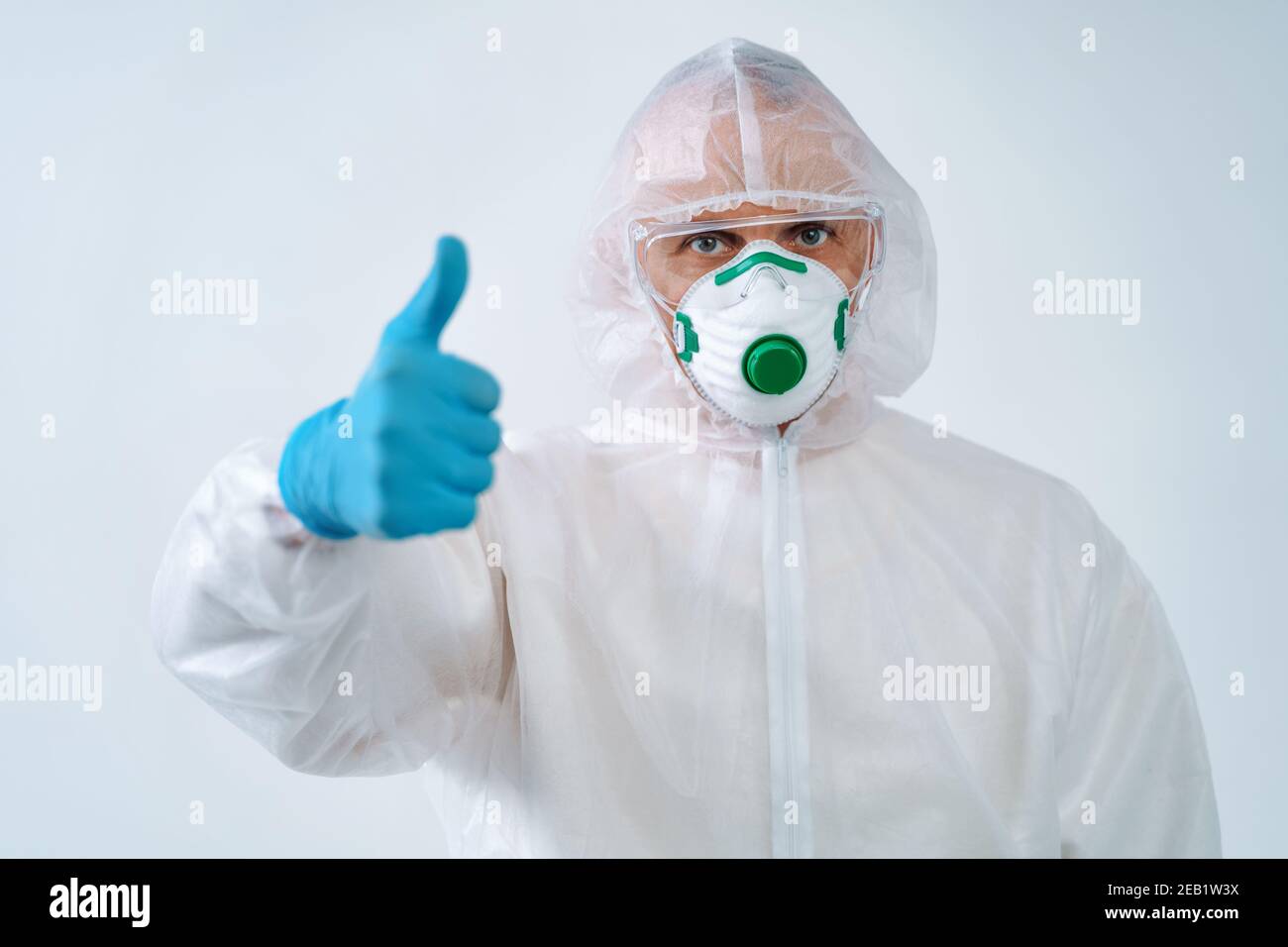 Trabajador de la salud mostrando pulgares hacia arriba gesto, para controlar un brote de virus Foto de stock