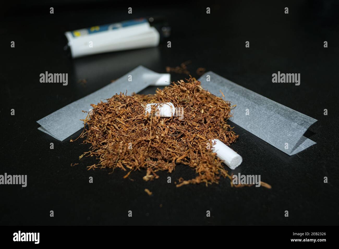 Mano el tabaco de liar, papel y filtros para hacer los cigarrillos en  madera rústica Fotografía de stock - Alamy