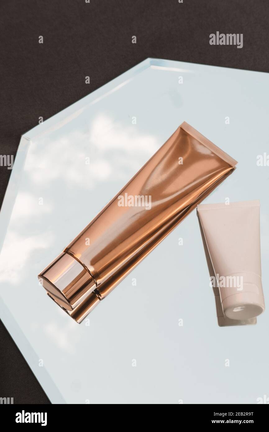 Dos de tubos cosméticos blancos y dorados sobre fondo de espejo, productos  de belleza, mockup de paquete de Marca, minimalista, vista superior  Fotografía de stock - Alamy