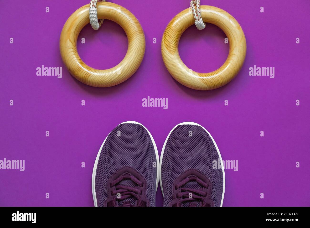 Anillos deportivos y zapatillas de deporte para entrenamientos en casa y en el gimnasio sobre un fondo lila. Concepto de cuidado corporal, estilo de vida activo. Vista superior. Espacio para texto. Foto de stock