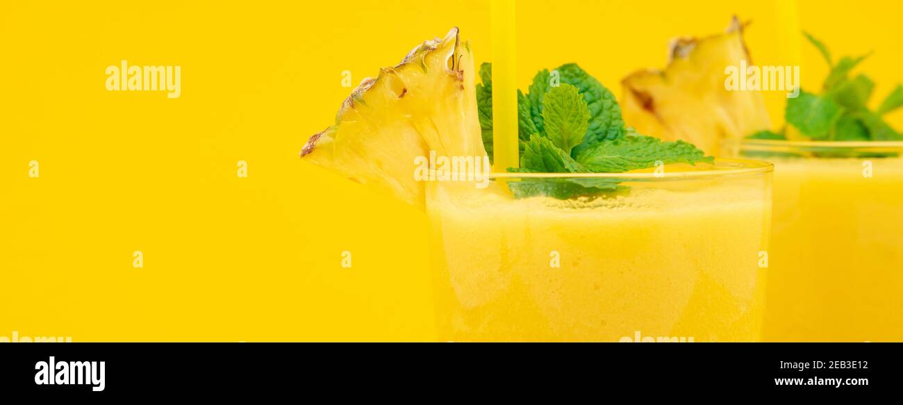 Refrescantes bebidas saludables batidos de piña en los vasos adornados con  hierbabuena sobre fondo de banner amarillo con espacio de copia Fotografía  de stock - Alamy