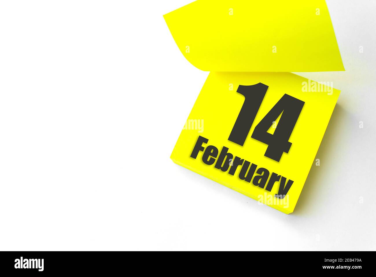 14 de febrero. Día 14 del mes, fecha del calendario. Primer plano en blanco Amarillo recordatorio de papel nota adhesiva sobre fondo blanco. Mes de invierno, día del año con Foto de stock