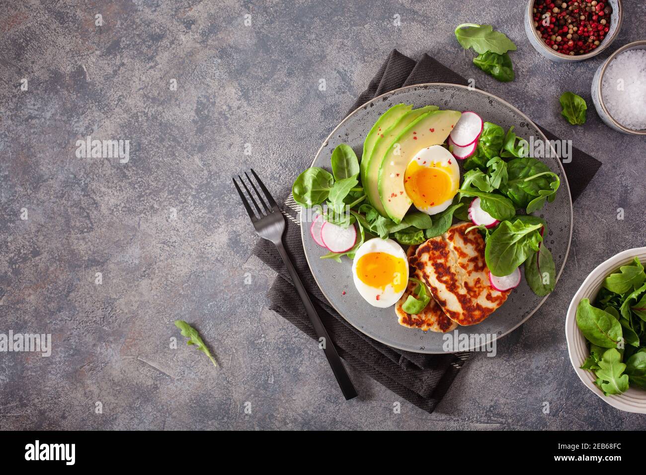 Ceto paleo dieta saludable Desayuno: huevos, aguacate, queso halloumi, ensalada de hojas Foto de stock