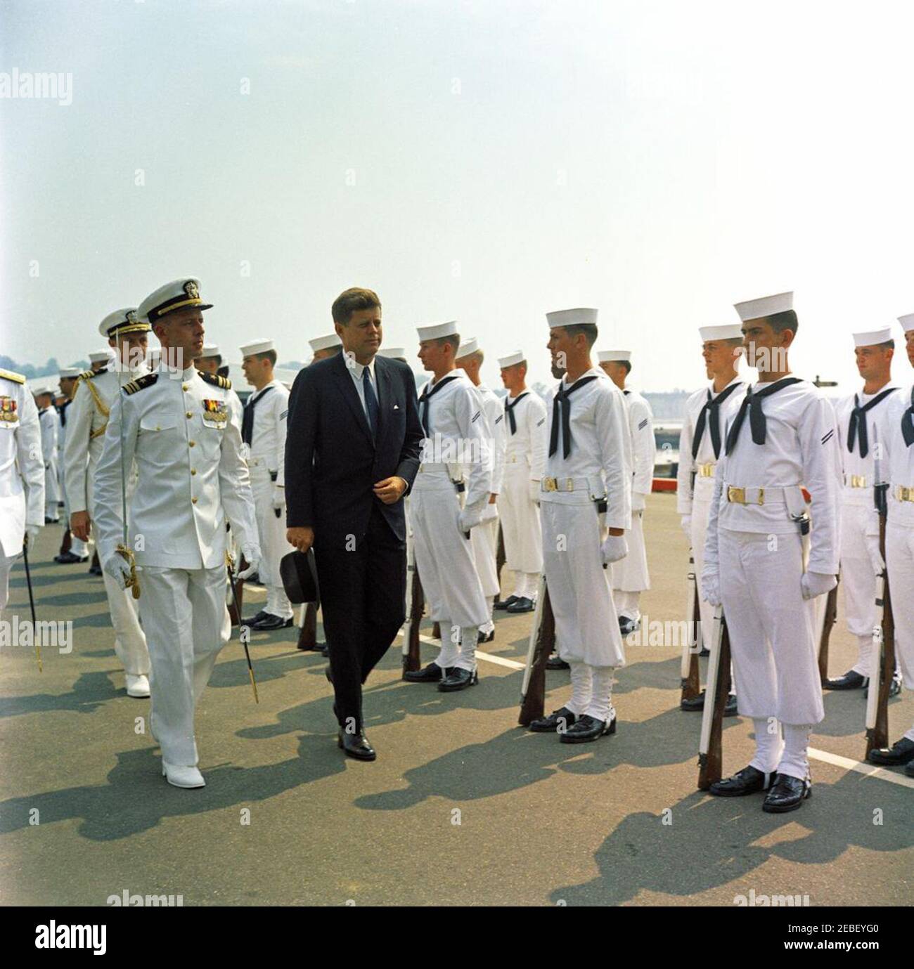 Discurso de inicio en la Academia Naval de EE.UU., Annapolis, Maryland, 11:04AM. El Presidente John F. Kennedy de camino a la ceremonia de inicio en la Academia Naval de los Estados Unidos, Annapolis, Maryland. También se incluyen en la fotografía el Aide Naval al Presidente Tazewell T. Shepard y la Guardia de honor de la Marina de los Estados Unidos. Foto de stock