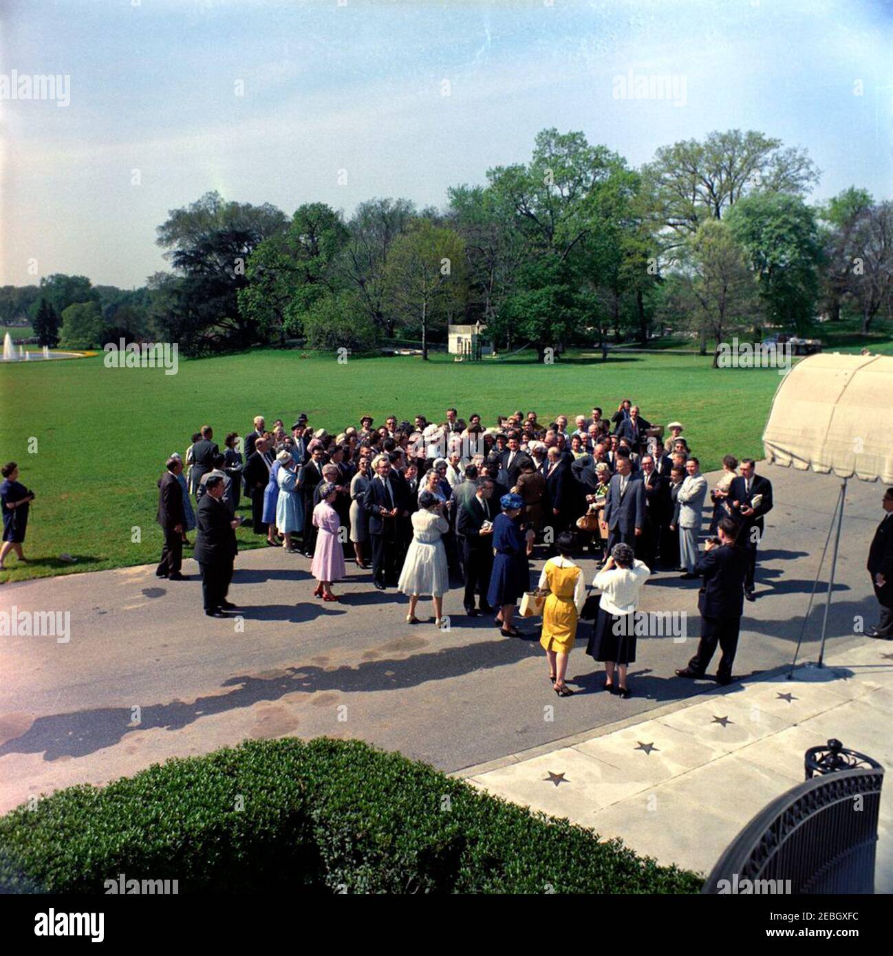 Visita de los miembros de los Caballeros de Colón, Charlestown, Massachusetts. El presidente John F. Kennedy (en público, centro de fondo) visita con miembros del Consejo de Bunker Hill de los Caballeros de Colón de Charlestown, Massachusetts. También en la foto: Asistentes Especiales del Presidente Kennedy, Dave Powers y John J. McNally; oficial de la Agencia de Comunicaciones de la Casa Blanca (WHCA), Joseph W. Culbreth; y agentes del Servicio Secreto de la Casa Blanca, Stewart u201cStuu201d Stout, Sam Sulliman, y Ernie Olsson. Camino de South Lawn en frente del Portico Sur, Casa Blanca, Washington, D.C. Foto de stock
