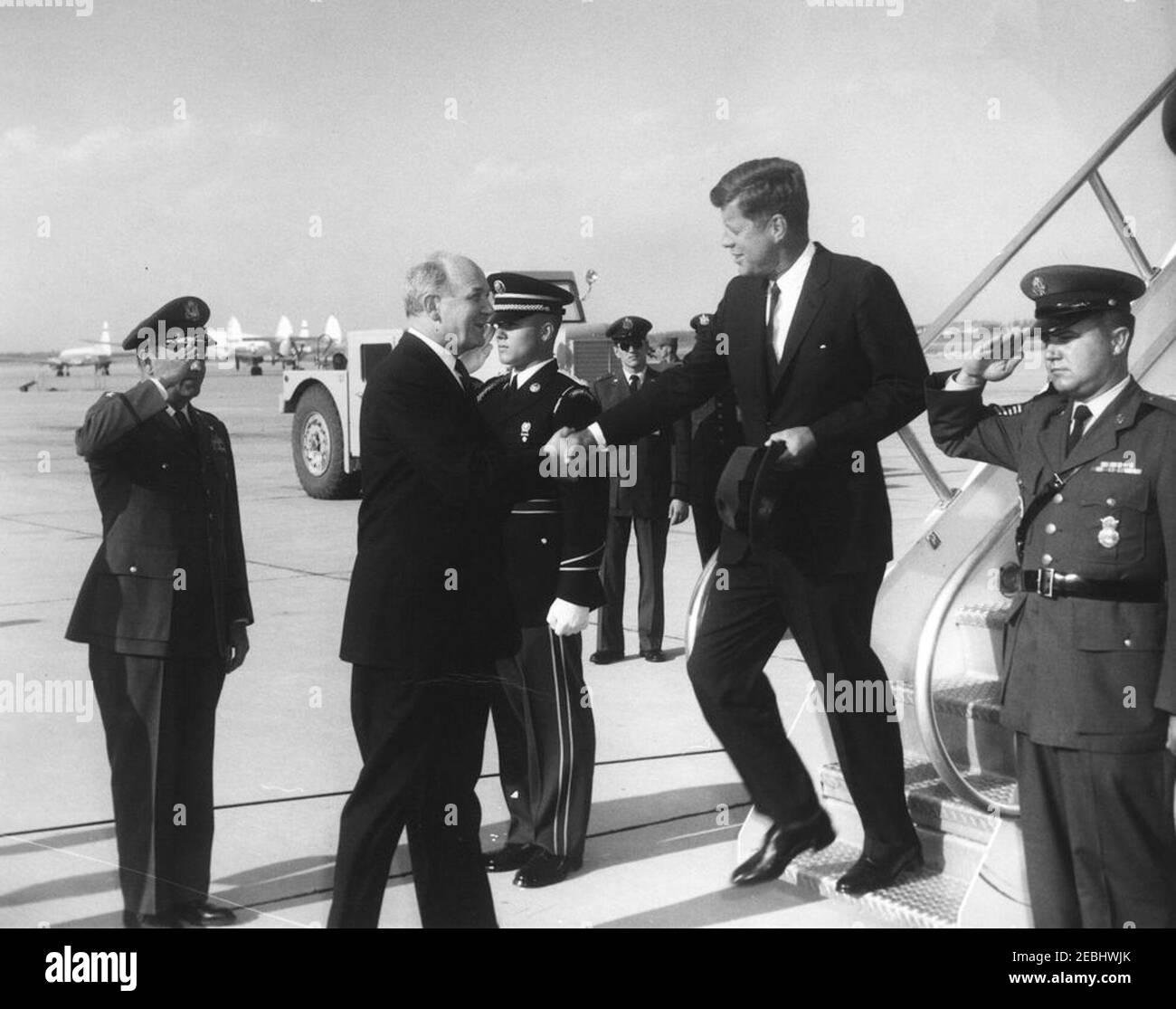 El Presidente Kennedy regresa a la base Andrews de la Fuerza Aérea desde las vacaciones de Semana Santa, 4:33 PM. El Presidente John F. Kennedy (sombrero de sujeción) se sacude de las manos con el Secretario de Estado, Dean Rusk, a su llegada a bordo de la Fuerza Aérea uno a la base Andrews de la Fuerza Aérea, Maryland, después de las vacaciones de Semana Santa en Palm Beach, Florida. Foto de stock