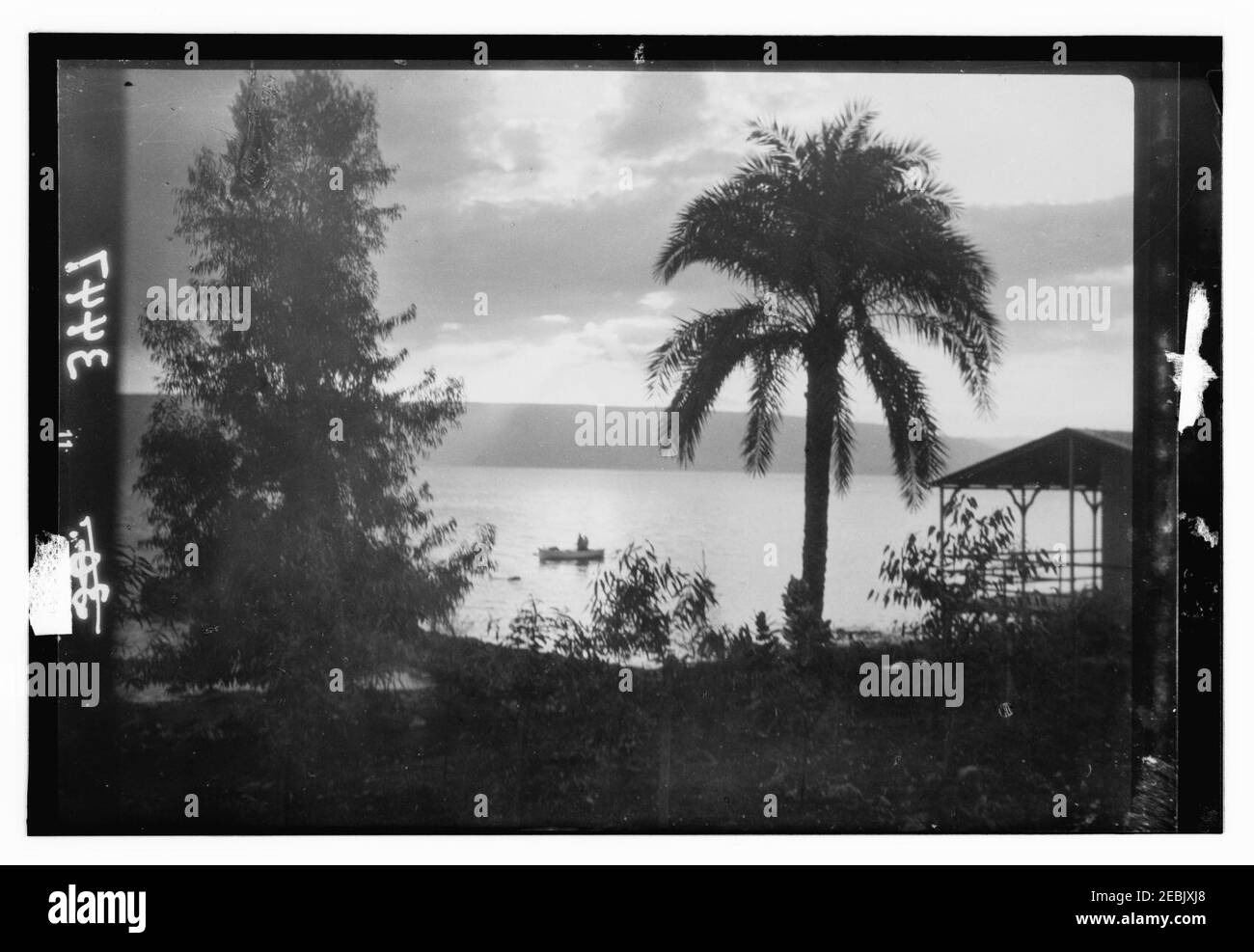 Vistas del norte. El lago de Galilea. Amanecer de Tiberias. Pintoresco con palmera y barco Foto de stock