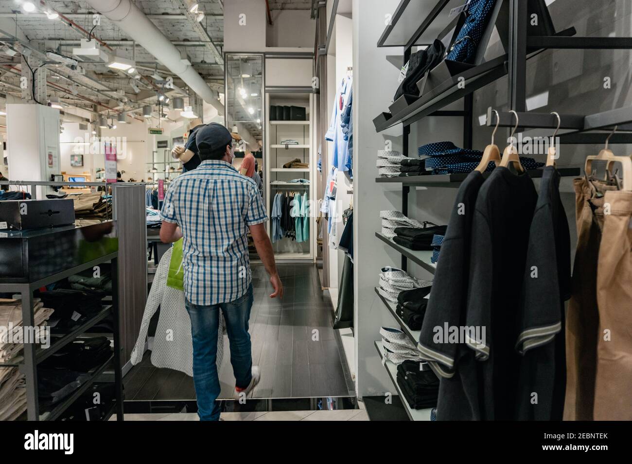 hombre de pie en la espalda en un centro comercial comprando ropa, con una  bolsa de compras en sus manos. Buenos Aires. Falabella Fotografía de stock  - Alamy