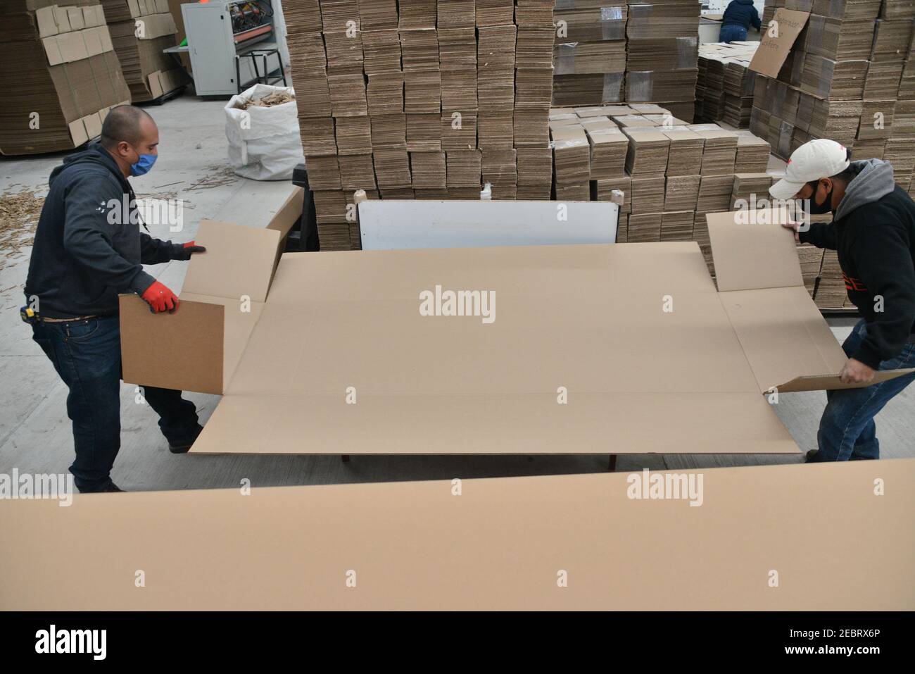 Toluca, Ciudad de México, México. 12 de febrero de 2021. Un trabajador de  la fábrica de cajas de cartón KJ, durante el montaje de un ataúd hecho de  cartón. Debido al aumento