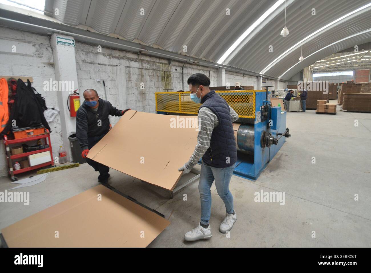 Toluca, Ciudad de México, México. 12 de febrero de 2021. Un trabajador de  la fábrica de cajas de cartón KJ, durante el montaje de un ataúd hecho de  cartón. Debido al aumento