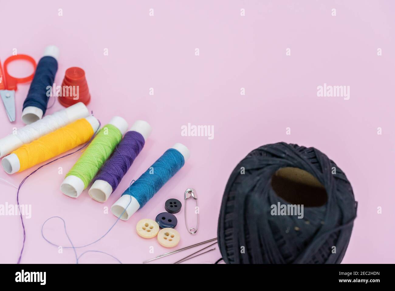 Costura de fondo. Accesorios para trabajos de aguja sobre fondo de madera. Bobinas de hilo, tijeras, botones, cinta métrica, suministros de costura. Configurado para la necesidad Foto de stock