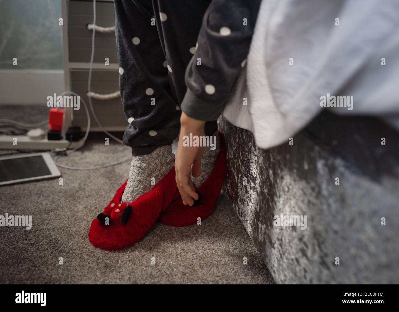 niña en pijama poniéndose sus zapatillas Fotografía de stock - Alamy