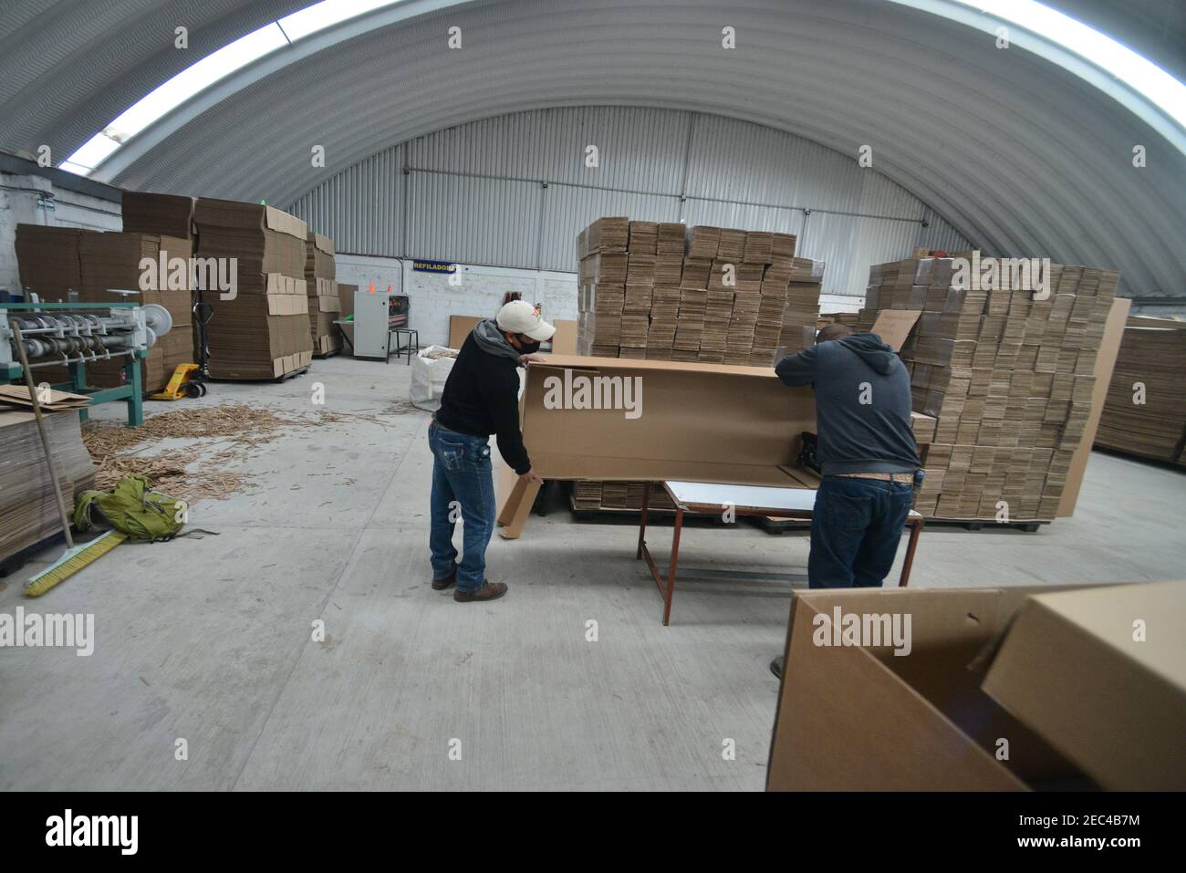 Toluca, México. 12 de febrero de 2021. Un trabajador de la fábrica de cajas de cartón durante el montaje de un ataúd hecho de Debido al aumento de las muertes