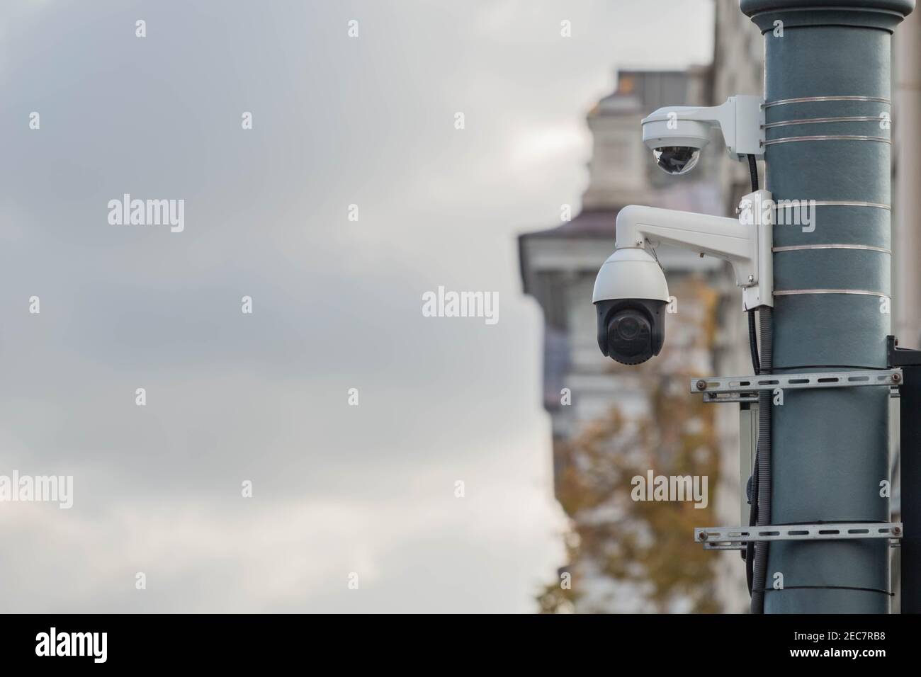 Vista de una cámara de vigilancia CCTV contemporánea unida a un poste de metal. cámara de vídeo de seguridad de 360 grados en la calle de la ciudad en el edificio clásico de la ciudad Foto de stock