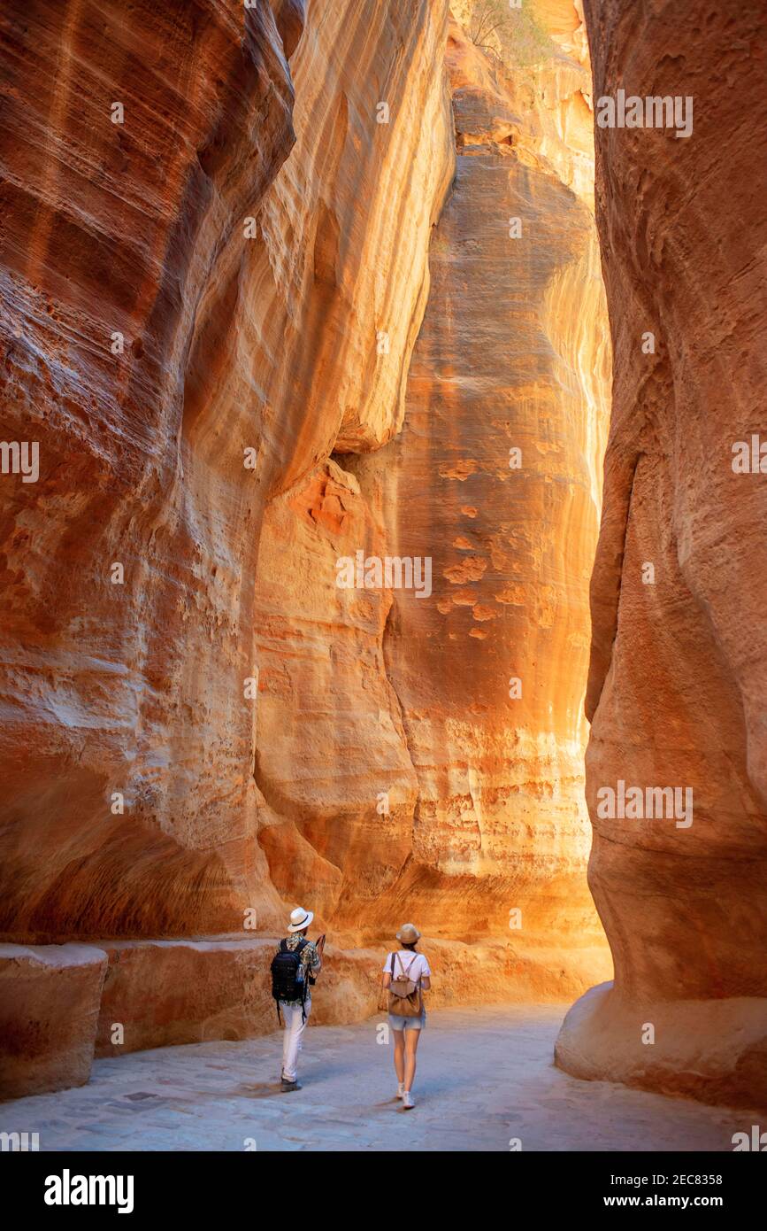 Turistas en el Siq, Petra, Patrimonio de la Humanidad de la UNESCO, Jordania. Exterior Siq Cañón Amarillo por la mañana Senderismo a la entrada en Petra Jordania Petra Jordania. Co Foto de stock