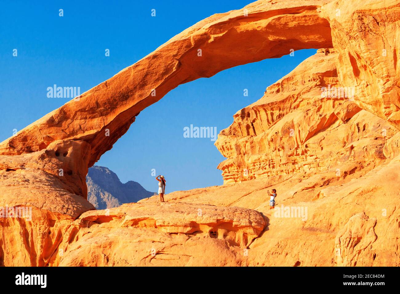 Senderismo en el arco de roca al Kharza o al Borg Alsagheer Wadi Rum, Jordania Foto de stock