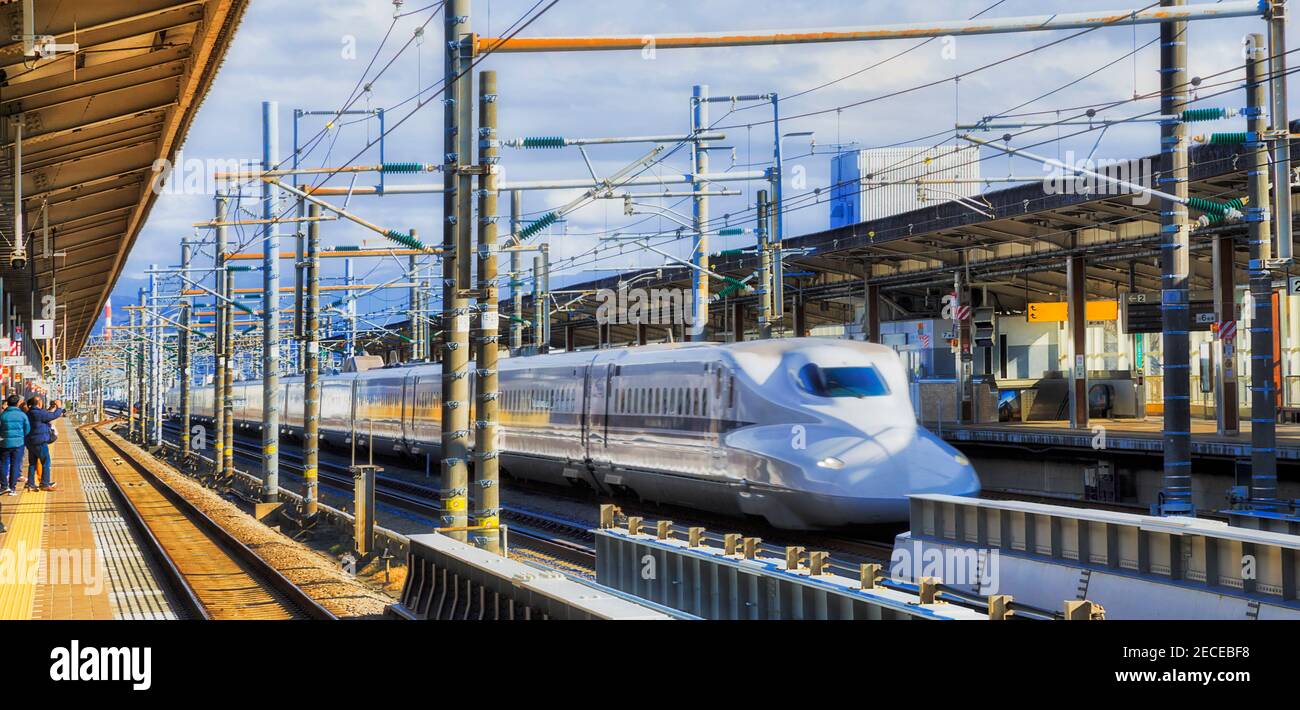 Amplia vista de las plataformas de estaciones de tren Express que pasan por la ciudad japonesa de Shin-Fuji en un día soleado. Foto de stock