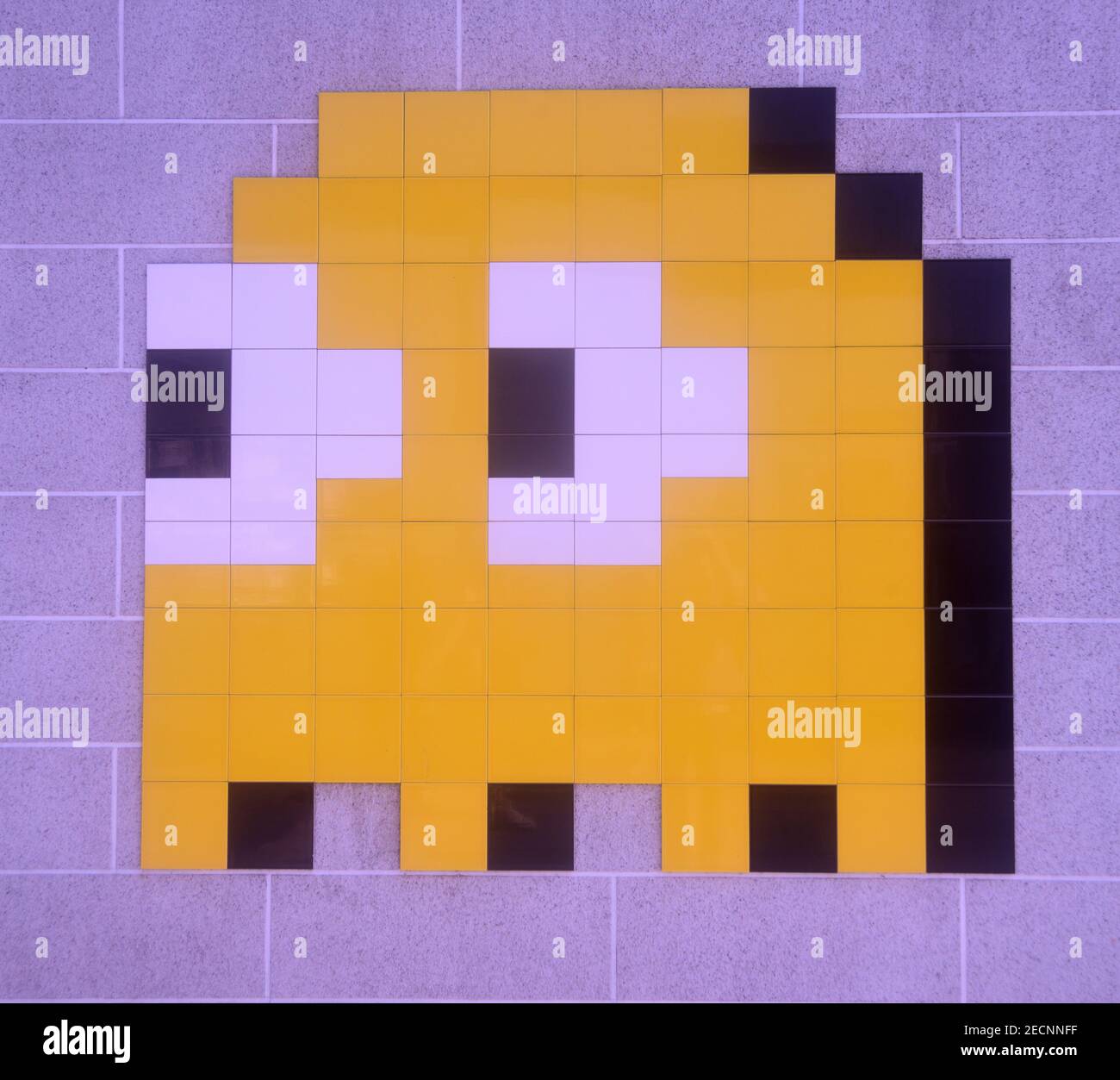 Imagen pixelada del personaje del juego de Pac Man Kinkky, formado por azulejos y montado en la pared Foto de stock