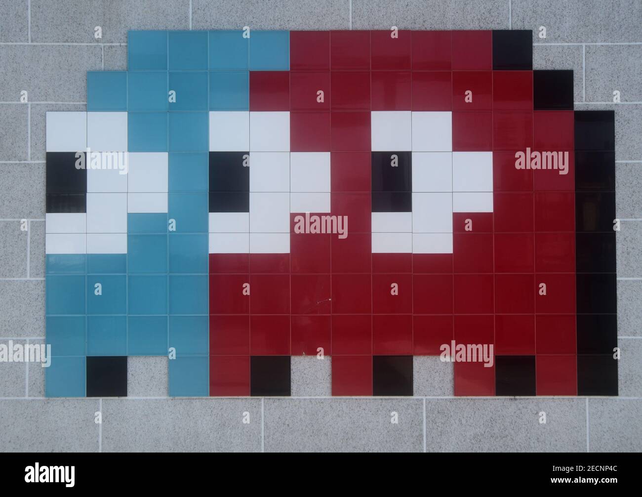 Imagen pixelada del personaje del juego Pac Man Inky y Blinky, formado por azulejos y montado en la pared Foto de stock