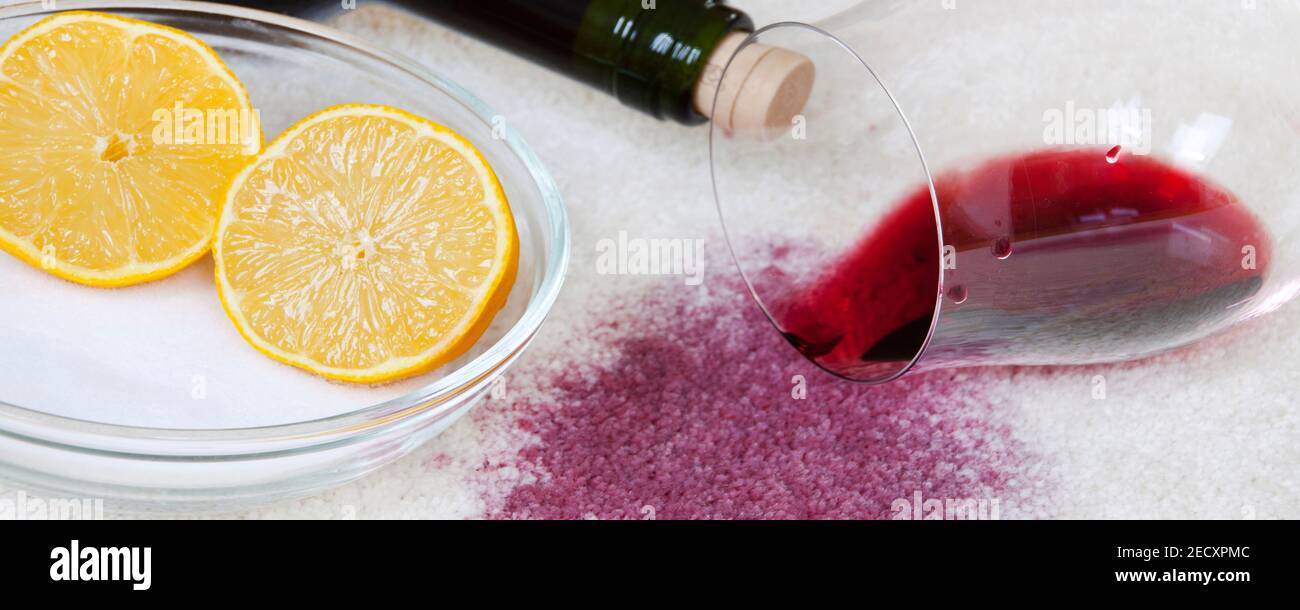 Umgestoßenes Weinglas mit Rotwein, Salz und Zitrone auf Teppich Haushaltsmittel Banner Foto de stock