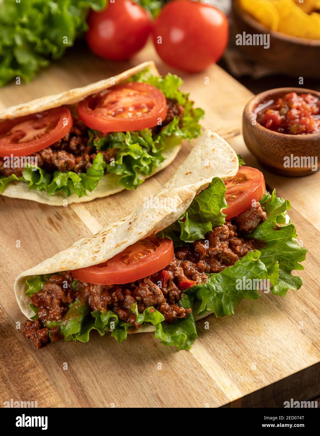 Taco de ternera con lechuga y tomate sobre corte de madera tabla con