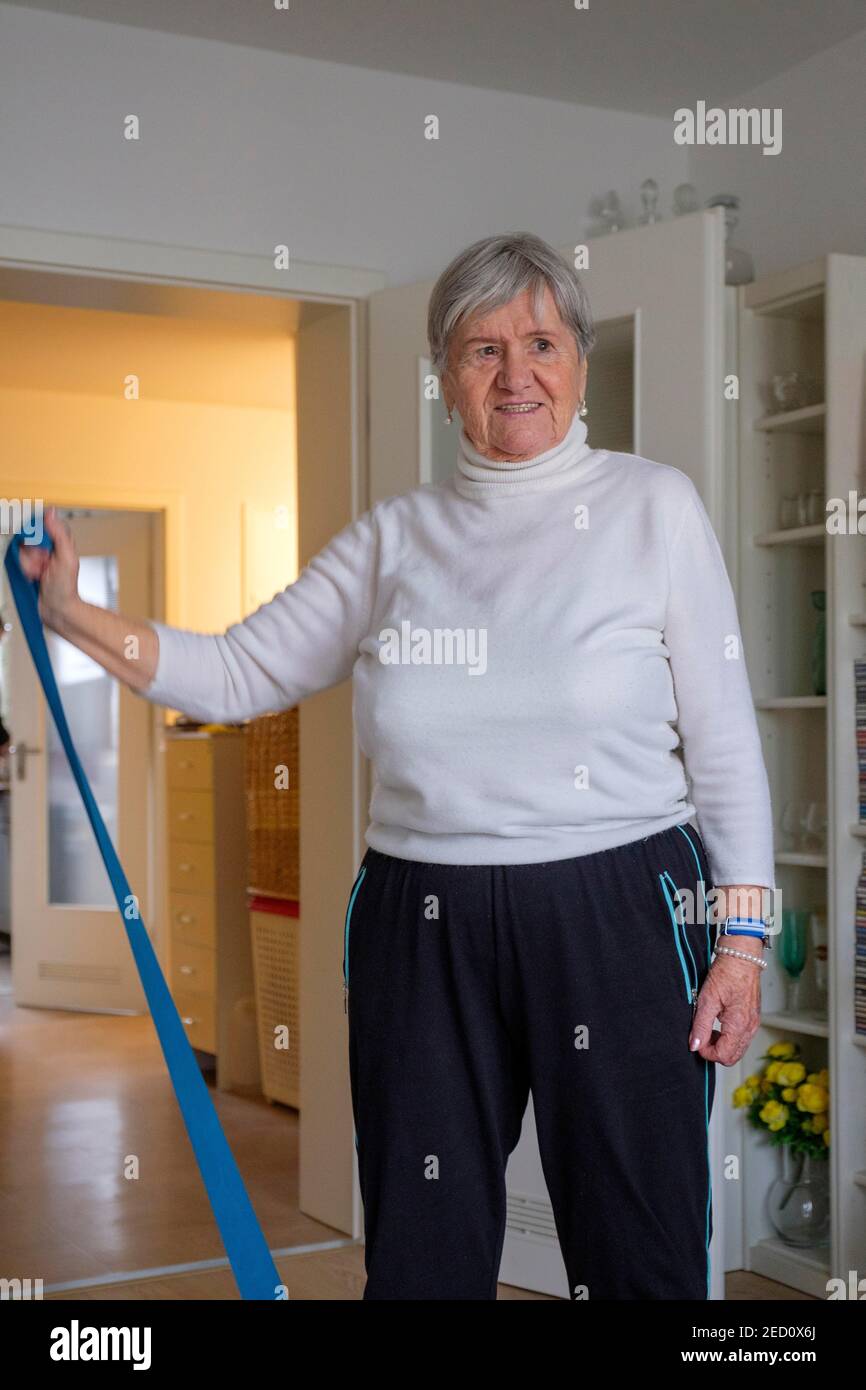 Mayor, mujer 87 años haciendo gimnasia en casa, aptitud en la vejez, cinta de fitness, alta baviera, baviera, alemania Foto de stock