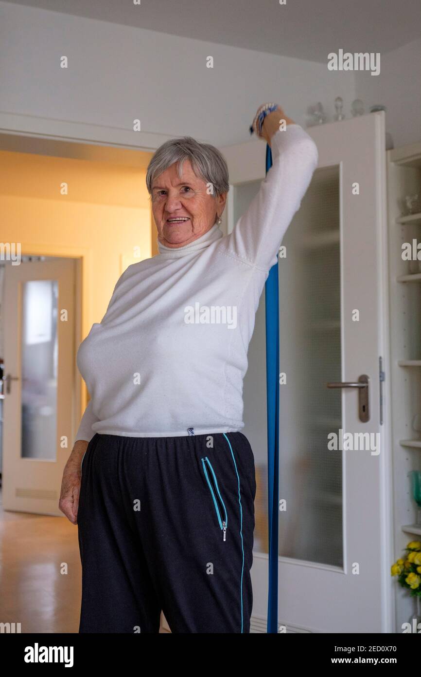 Mayor, mujer 87 años haciendo gimnasia en casa, aptitud en la vejez, cinta de fitness, alta baviera, baviera, alemania Foto de stock