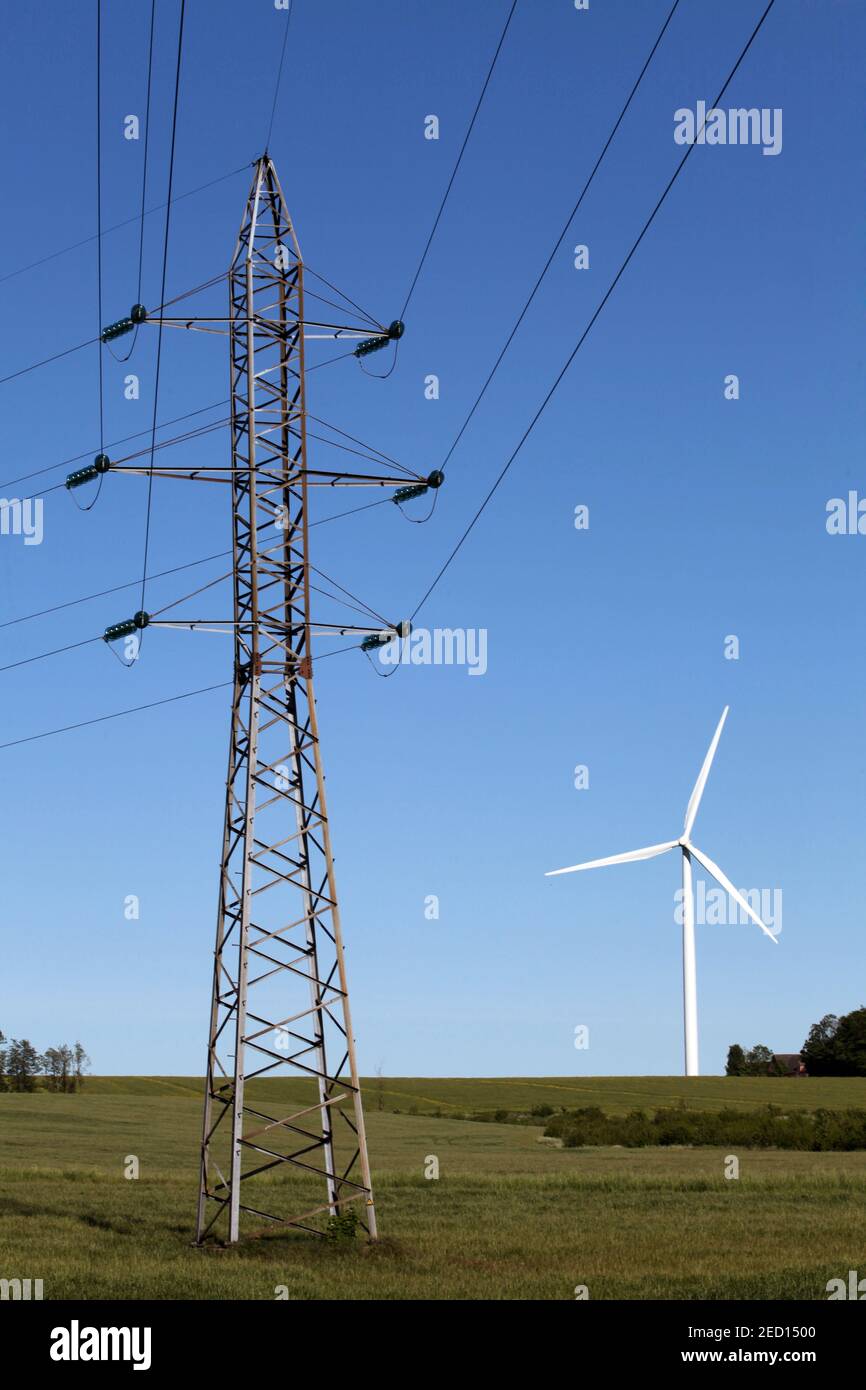 Cables eléctricos de alta tensión y un aerogenerador Foto de stock