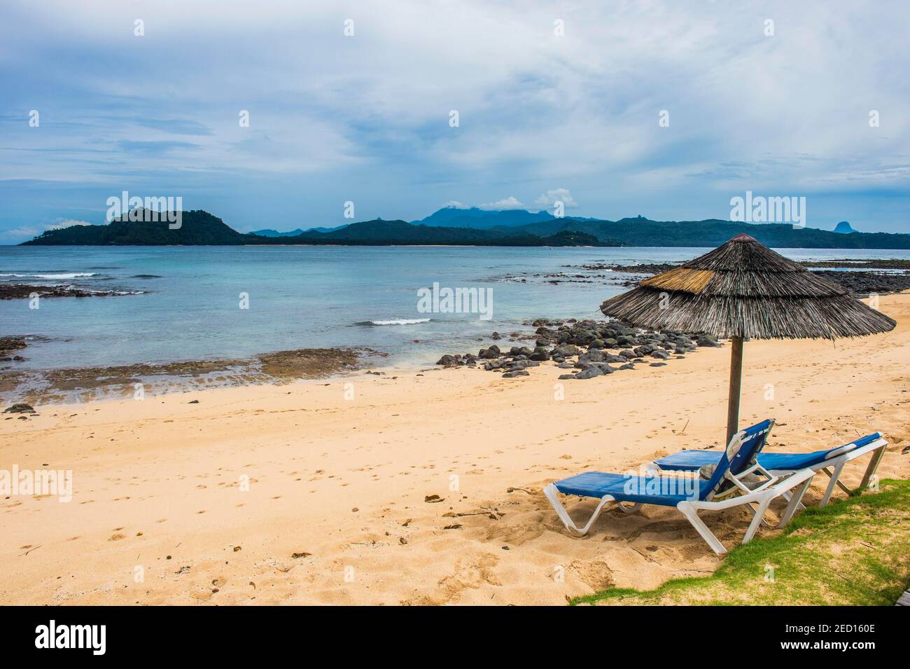 Sun se encuentra en una playa de arena de un hotel de cuatro estrellas en Ilheu das Rolas, Santo Tomé y Príncipe, océano Atlántico Foto de stock