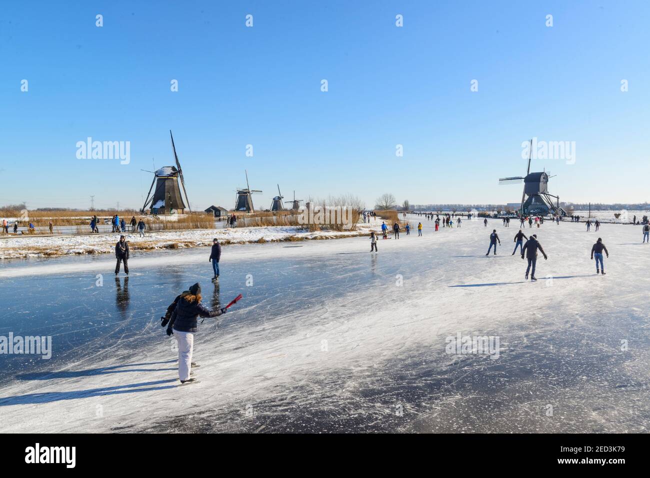 Patinaje sobre hielo entre los molinos de viento de Kinderdijk en el invierno de 2021. Países Bajos Foto de stock