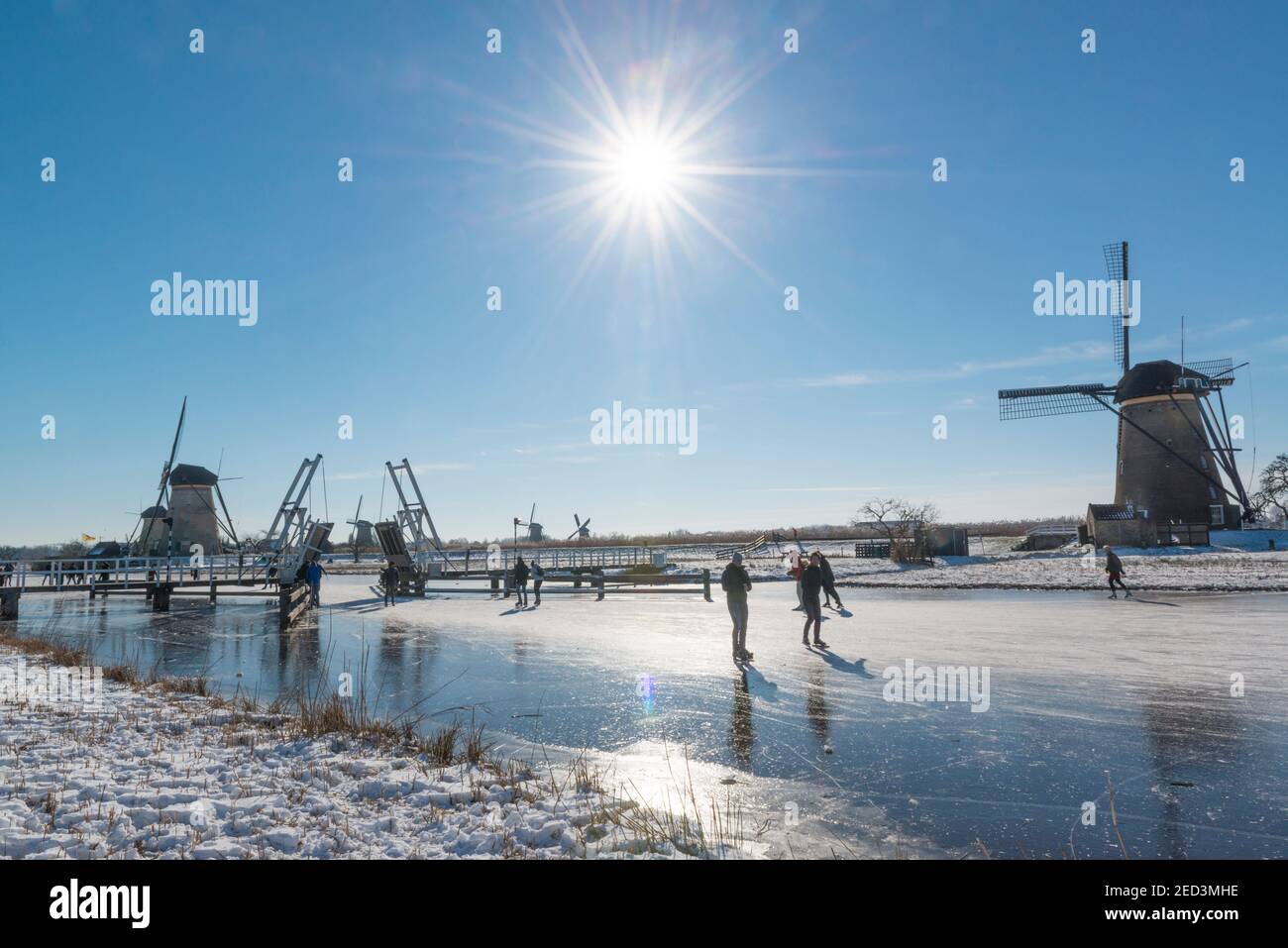 Patinaje sobre hielo entre los molinos de viento de Kinderdijk en el invierno de 2021. Países Bajos Foto de stock