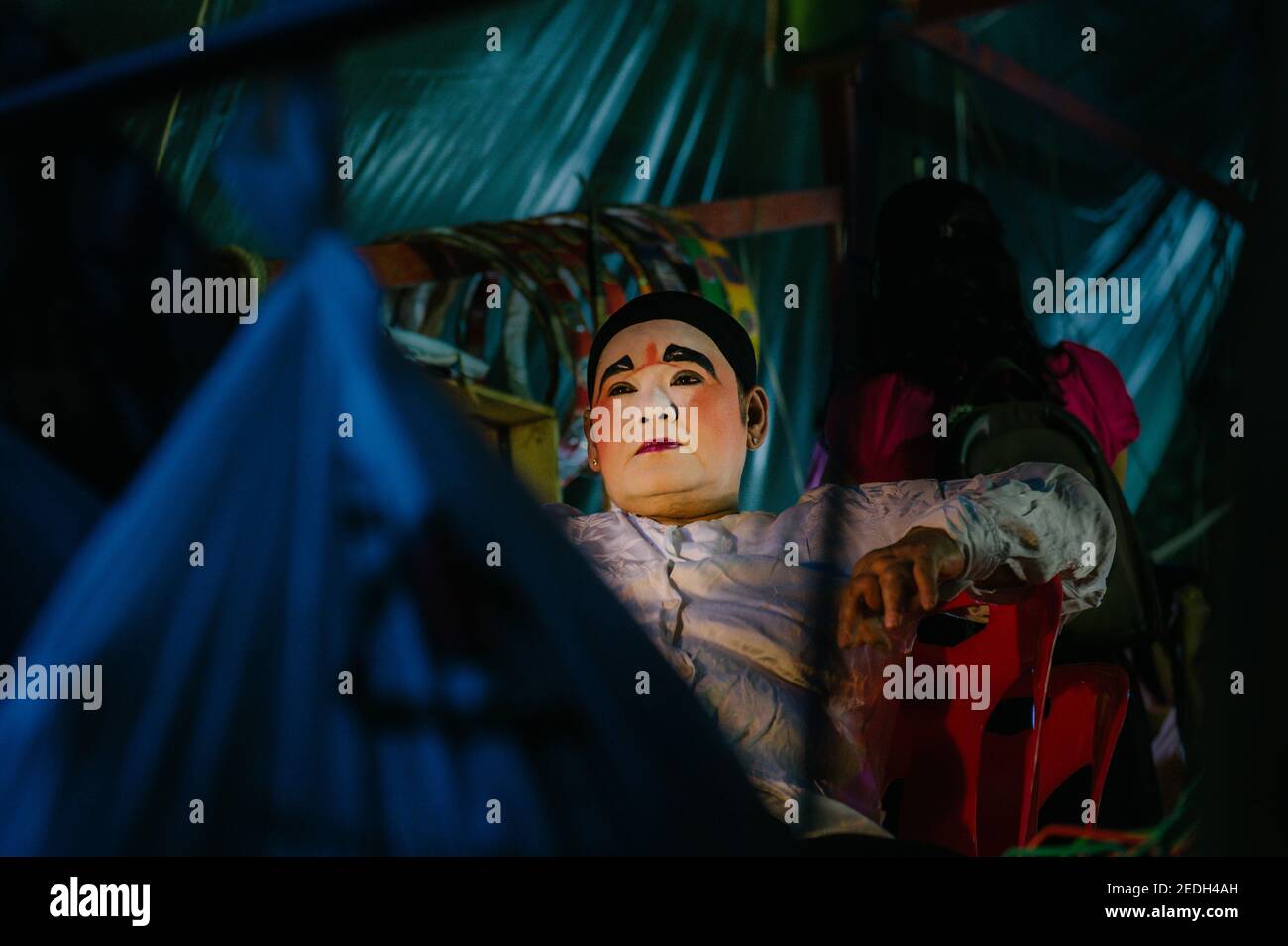 Una jugadora de ópera China tailandesa está sentada entre bastidores, preparándose para el espectáculo Foto de stock