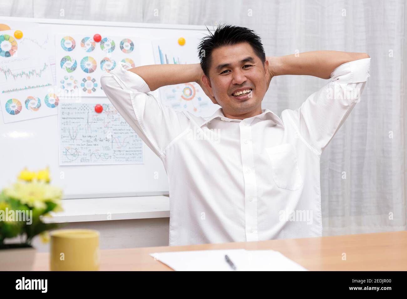 Un hombre de negocios asiático sentado en la oficina en casa mira la cámara haciendo una entrevista de trabajo en línea durante una conferencia de chat. Vista de webcam. Gente de negocios sonriendo Foto de stock