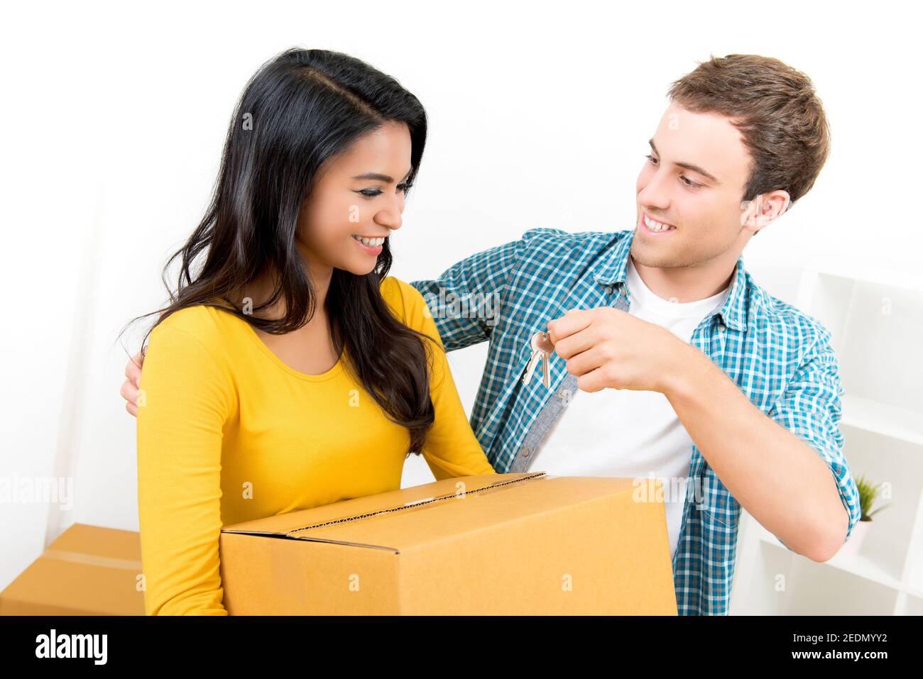 Una pareja interracial joven y encantadora que acaba de mudarse a una casa nueva Foto de stock