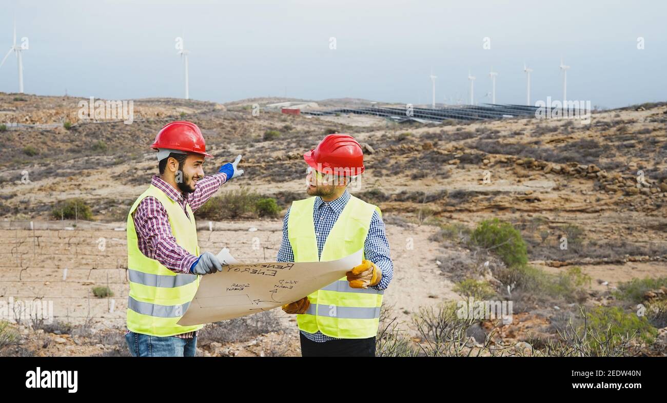 Ingenieros obreros leyendo y hablando sobre la nueva energía renovable proyecto - concepto eco sostenible Foto de stock