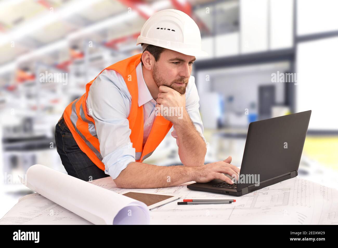 Ingeniero en su lugar de trabajo con el portátil en una empresa industrial en ingeniería mecánica Foto de stock