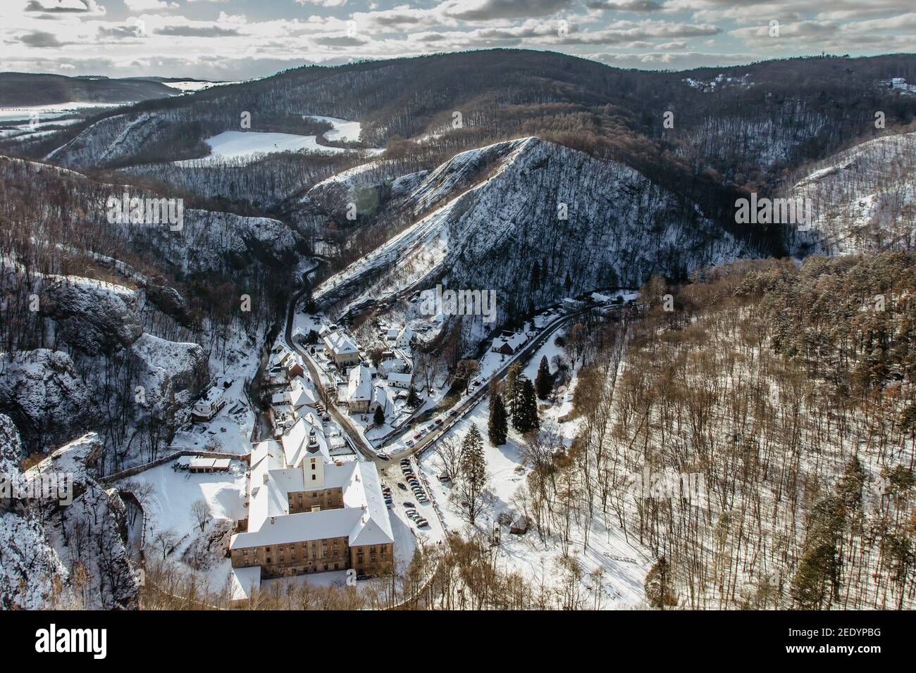 Vista aérea de invierno de Svaty Jan pod Skalou, pequeño pueblo pintoresco en Bohemia Central, República Checa. Monasterio escondido bajo acantilados y rocas Foto de stock